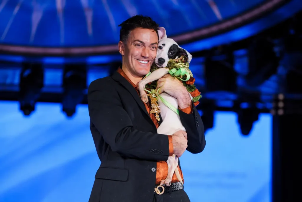 Hombre feliz abraza perro en gala azul